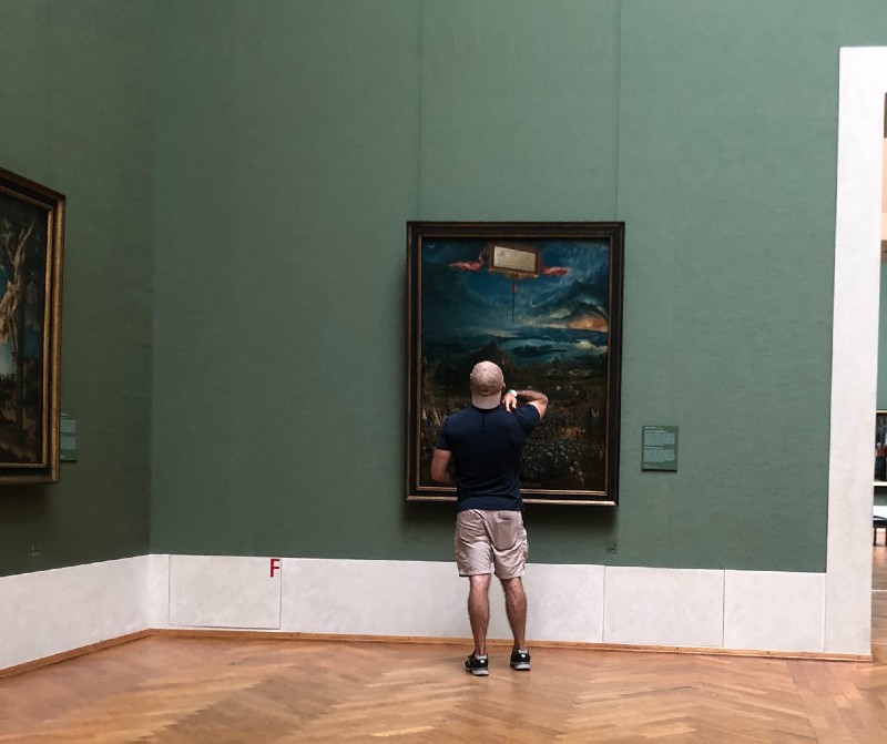 Man looking at a painting in the Alte Pinakothek Museum